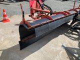 a snow plow sitting on the ground in the parking lot