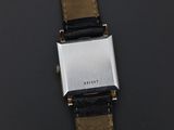 a close up of a watch on a black surface