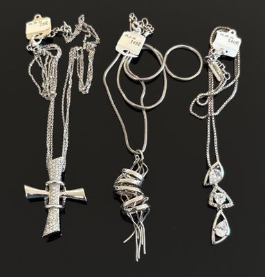 trois colliers en argent ornés d'une croix et d'un nœud sur une chaîne