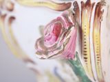 a close up of a vase with a rose on it