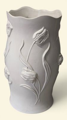 un vase blanc avec des fleurs posé sur une table
