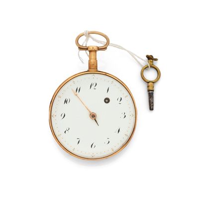 a gold pocket watch with a key attached to it