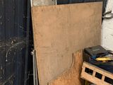 un tas de bric-à-brac dans un garage, à côté d'une porte métallique