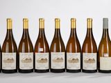 six bouteilles de vin sont alignées sur une table