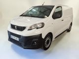 La camionnette blanche est garée sur le sol blanc de la pièce.