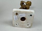 a small statue of a bird sitting on top of a white box