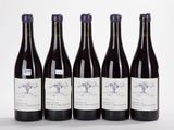 six bottles of wine are lined up in a row on a white surface