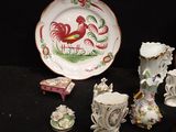 a plate with a rooster on it next to a plate with a cup and saucer on it