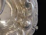 a silver plate with a clock on it on a black background
