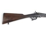 un vieux fusil avec un canon en bois et une poignée en bois