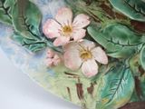 a close up of a decorative plate with flowers on it