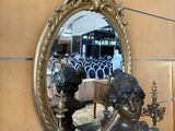 une statue représentant une femme assise devant un miroir