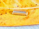 une feuille jaune sur laquelle se trouve un petit morceau d'argent