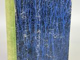 un livre bleu et vert posé sur une surface blanche