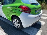 a green and white car parked on the side of the road