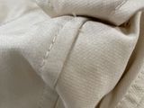 close up of a person ' s hand stitching a piece of fabric