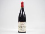 une bouteille de vin rouge posée sur une table blanche