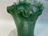 a green vase that is sitting on a white cloth