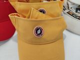 several hats are lined up on a table with tags on them