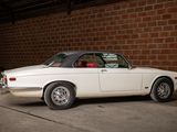 a white car that is parked in front of a brick wall