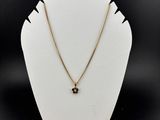 un mannequin blanc portant une chaîne en or et un pendentif en diamant noir