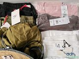 a suitcase full of clothes and headphones on a bed