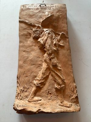 sculpture en argile représentant un homme tenant une batte de baseball, posée sur une surface blanche
