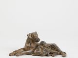 a bronze statue of a dog laying down next to a cat