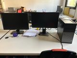 deux écrans d'ordinateur posés sur un bureau dans un bureau
