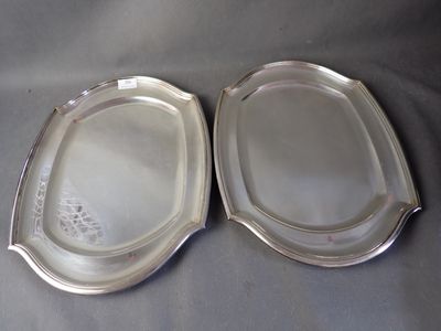 pair of silverplated serving dishes on a gray table cloth