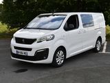 la camionnette blanche est garée sur le parking à côté des arbres