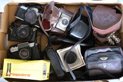 une boîte en carton remplie de vieux appareils photo et d'autres objets