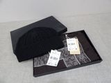 un chapeau noir et une écharpe dans une boîte posée sur une table