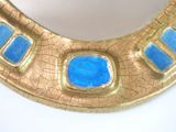 a gold and blue mirror on a white table