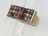 un gros plan d'une bague en or ornée d'une pierre rose au centre