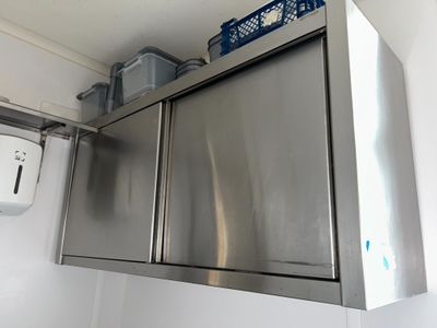 une armoire en acier inoxydable dans un coin de la salle de bains