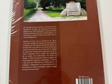 the back cover of a book with a picture of a road and trees in the background