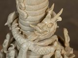 a white vase with a dragon on top of it