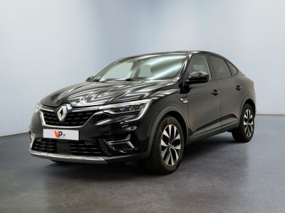 Une voiture noire est garée dans une pièce aux murs blancs.