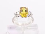 a close up of a yellow sapphire and diamond ring on display