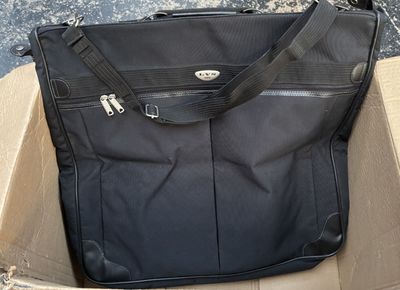 un sac noir posé dans une boîte posée par terre