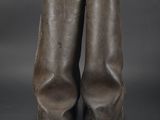 a pair of brown leather boots sitting on top of a black surface