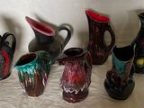 cinq vases de couleurs différentes posés sur une table