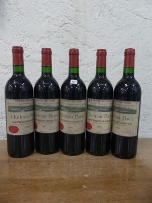 quatre bouteilles de vin rouge sont alignées sur une table