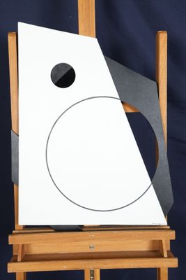 un chevalet sur lequel est posé un tableau, avec une feuille de papier posée dessus