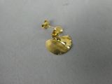 gros plan d'une paire de boucles d'oreilles en or sur une surface blanche