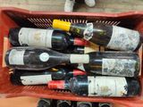 many bottles of wine in a red basket on a table