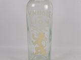 a glass bottle with a gold lion on it