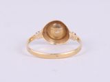 a close up of a gold ring with a pearl in the center