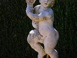 a statue of a boy holding a flower in his hand